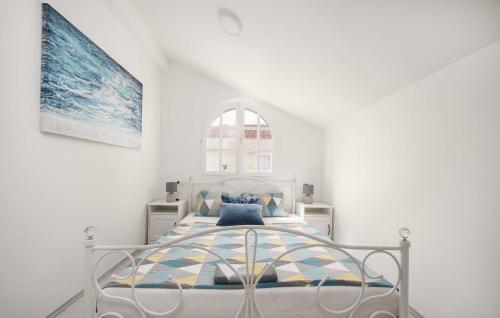 a white bedroom with a bed with blue pillows at Vila MS2 in Tribunj