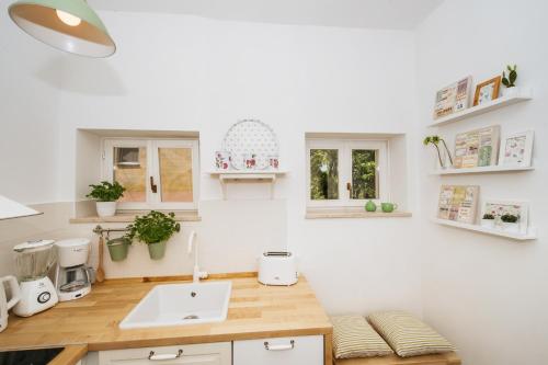 cocina blanca con fregadero y encimera en Apartments Jadera, en Zadar