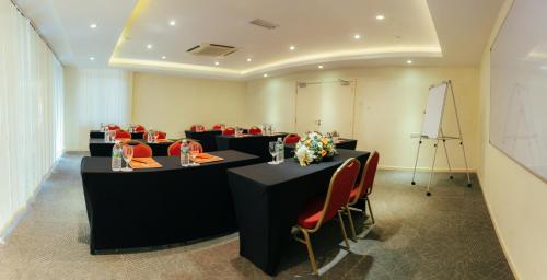 a conference room with black tables and red chairs at Hotel Sentral Kuantan @ Riverview City Centre in Kuantan