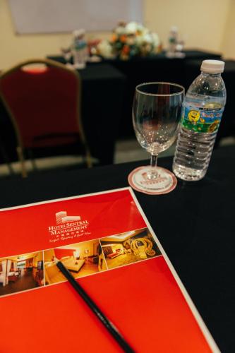 a table with a book and a glass of water at Hotel Sentral Kuantan @ Riverview City Centre in Kuantan