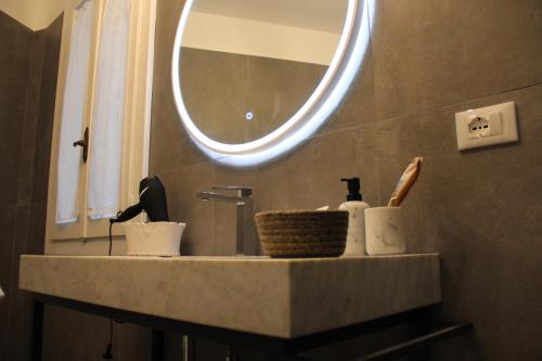 a bathroom sink with a round mirror above it at Il Giardino della Scuncerta in Lecce
