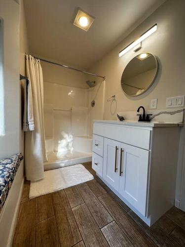 a bathroom with a shower and a sink and a mirror at The Alfred, Downtown Chehalis in Chehalis