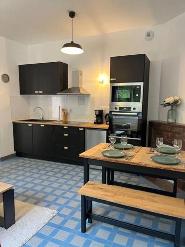 une cuisine avec une table avec des verres à vin dessus dans l'établissement Chez Mimi, la route des fruits, à Jumièges