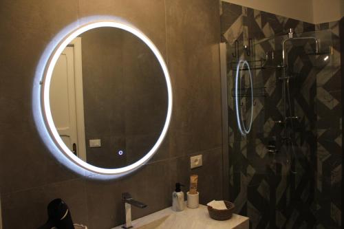 a bathroom with a round mirror and a sink at Il Giardino della Scuncerta in Lecce
