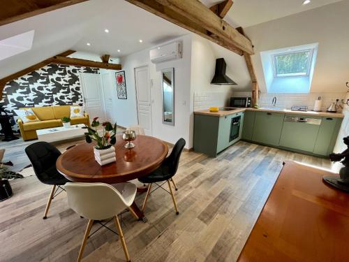 eine Küche und ein Wohnzimmer mit einem Tisch und Stühlen in der Unterkunft Cave Auger La Maison d'Hôtes in Restigné