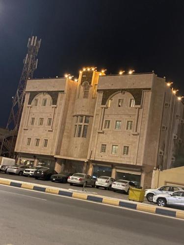 a large building with cars parked in front of it at نسيم البحر in Yanbu