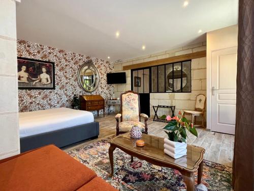 a hotel room with a bed and a couch at Cave Auger La Maison d'Hôtes in Restigné