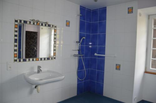 ein Bad mit einem Waschbecken und einem Spiegel in der Unterkunft Moulin de la Cuse - L'îlote in Cusance