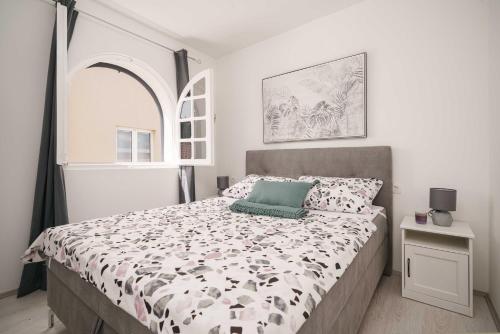 a bedroom with a bed with a black and white comforter at Vila MS in Tribunj