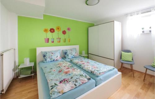 ein Schlafzimmer mit einem Bett und einer grünen Wand in der Unterkunft Nice Apartment In Horhausen With Wifi in Horhausen