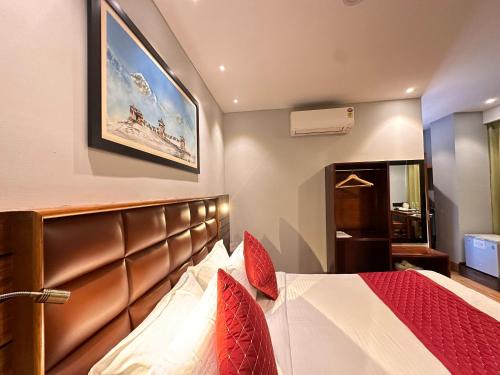 - une chambre avec un grand lit et des oreillers rouges dans l'établissement NUMINOUS HOTEL, à Thimphou