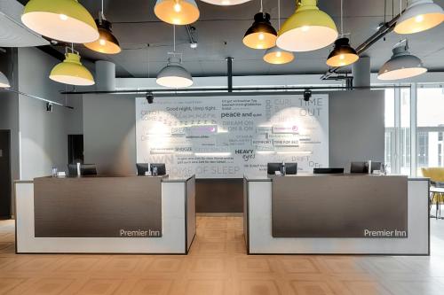 a large screen in a room with tables and chairs at Premier Inn Wolfsburg City Centre in Wolfsburg