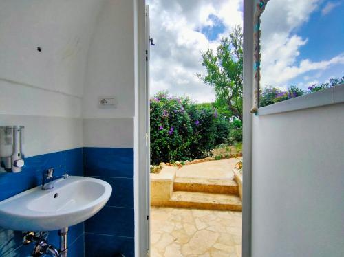 an open door to a bathroom with a sink at La Nuova Tenda di Casa Camilla Journey in Marina Serra