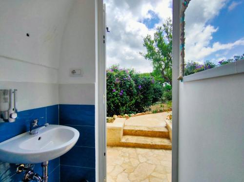 an open door to a bathroom with a sink at Tende Glamping Vista Mare Marina Serra in Marina Serra