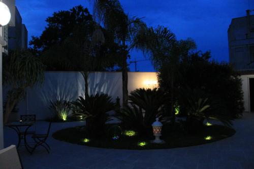 a garden with plants and lights at night at Il Giardino della Scuncerta in Lecce