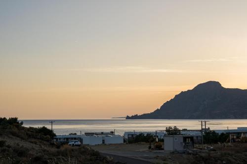 a view of the ocean and a mountain at sunset at Corallia villas near the beach in Plakias