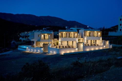 a house with lights in front of it at night at Corallia villas near the beach in Plakias