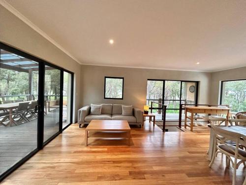 a living room with a couch and a table at Rosella - Bushland Hideaway in Yallingup