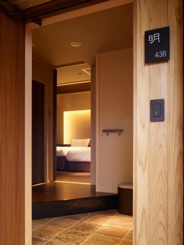 a door leading to a bedroom with a bed at Laforet Shuzenji Sanshisuimei in Izu
