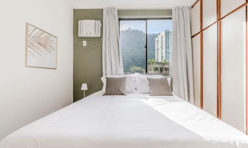 a large white bed in a room with a window at Tabas Lindíssimo apto na Gávea - RJ GV0001 in Rio de Janeiro