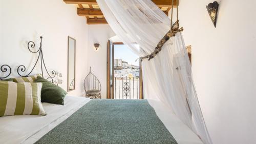 a bedroom with a white bed with a canopy at Casa Lunarito in Vejer de la Frontera