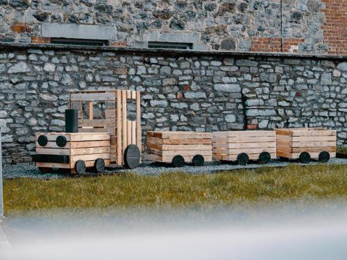 a wooden toy tractor sitting next to a stone wall at La porte du paradis in La Roche Madoux