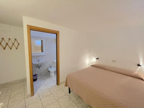 a bedroom with a bed and a bathroom with a toilet at Le camerine in Cecina