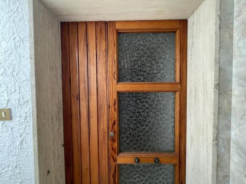 una puerta de madera con una ventana de cristal en Le camerine en Cecina