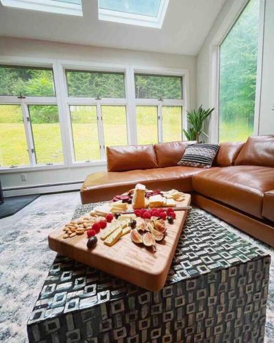 a living room with a couch and a tray of food at Modern, Cozy Hudson Valley Escape 1 Hr From NYC in Putnam Valley