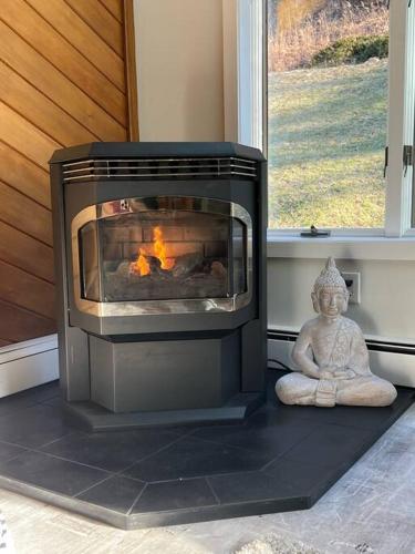 a fireplace with a statue sitting next to a window at Modern, Cozy Hudson Valley Escape 1 Hr From NYC in Putnam Valley