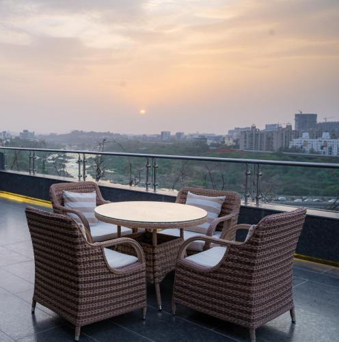 a table and chairs on a balcony with a view at The Westin Pune Koregaon Park in Pune
