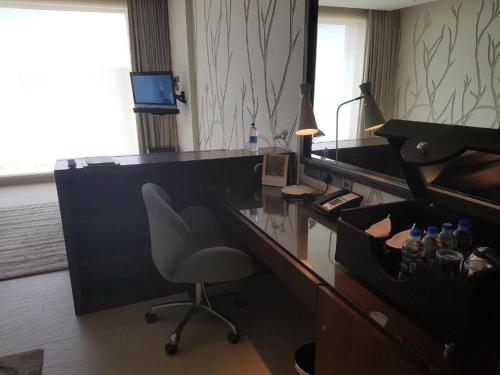 an office with a desk with a chair and a desk with a mirror at Taj Yeshwantpur Bengaluru in Bengaluru
