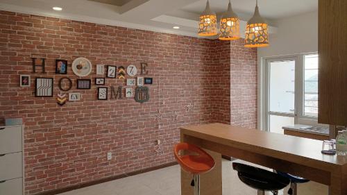 a kitchen with a brick wall and a wooden table at An's Oceanus in Nha Trang