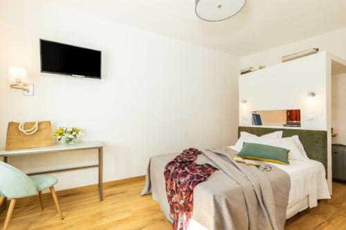 a bedroom with a bed and a desk and a tv at Monte Forru in Baunei