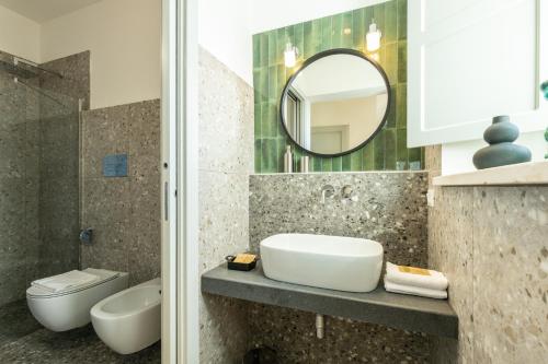 a bathroom with a sink and a toilet and a mirror at Monte Forru in Baunei