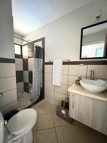 a bathroom with a toilet and a sink and a shower at High Tide 2 bed1 bath condo Terrace in Coco