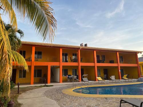 een oranje gebouw met een zwembad ervoor bij Hermosa Paradise Mins From Beach in Playa Hermosa