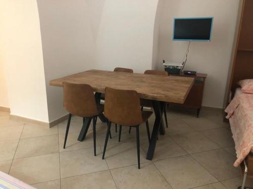a dining room table with chairs and a television at casa gramazio in Manfredonia