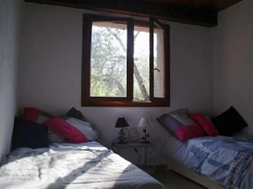 une chambre avec deux lits et une fenêtre dans l'établissement QUIET COTTAGE NEAR CITY CENTER, à Porto-Vecchio