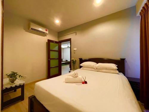 a bedroom with a large white bed with towels on it at Platinum Homestay in Batu Caves