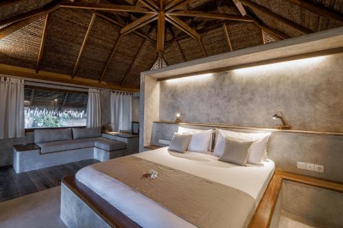 um quarto com uma cama grande e um sofá em Coral Eye Boutique Resort and Marine Outpost em Likupang