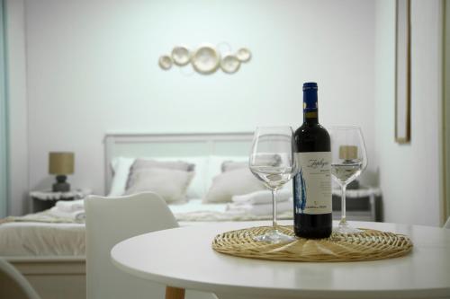 Una botella de vino y dos copas de vino en una mesa en Shabby Roman Studio- ai fori Imperiali, en Roma
