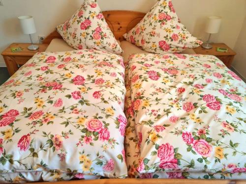 2 camas com roupa de cama e almofadas florais em Apartment Pusteblume mit Balkon, neu teilrenoviert em Sankt Martin