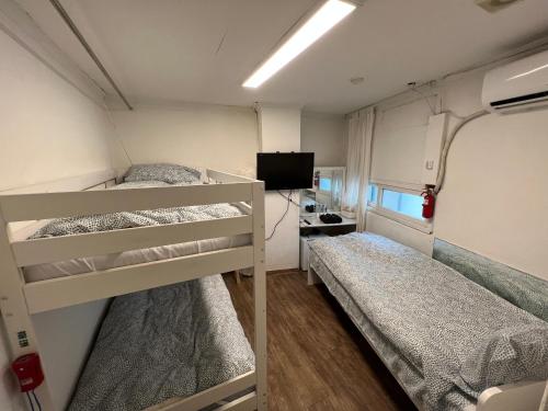 a small room with two bunk beds and a television at Hostel Metro in Seoul