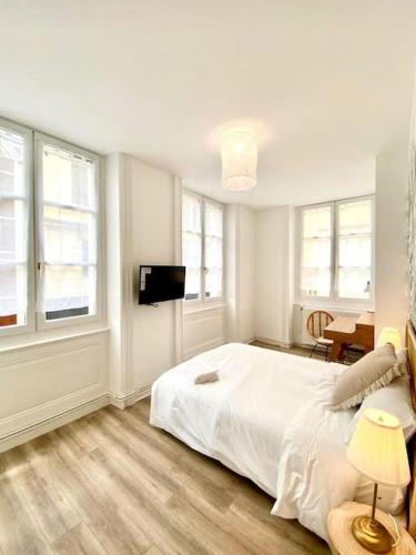 1 dormitorio blanco con 1 cama y TV de pantalla plana en Terracotta, en Saint-Étienne