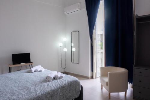 um quarto com uma cama, uma cadeira e uma janela em Seaport #Rooms em Trani