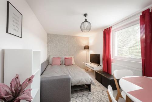 - une chambre avec un lit doté d'oreillers roses et d'une table dans l'établissement Ljubljana sLOVEnia + FREEparking & Bikes, à Ljubljana