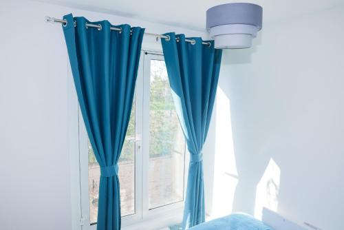 una ventana con cortinas azules en una habitación en Cosy Two Bedroom Apartment en Londres