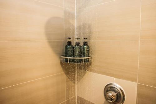 un grupo de botellas sentadas en una ducha en Cosy Two Bedroom Apartment en Londres