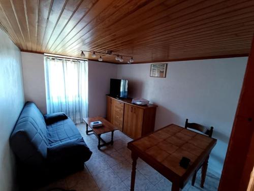 un salon avec un canapé bleu et une table dans l'établissement Maison de village, à Sisco